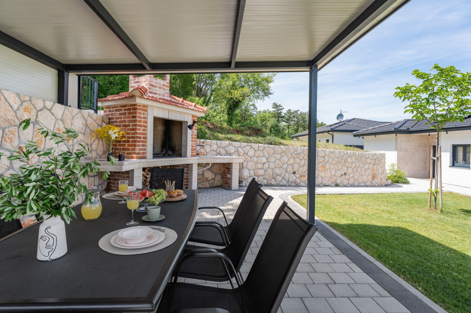 The outdoors offers a covered dining area for 8 people.