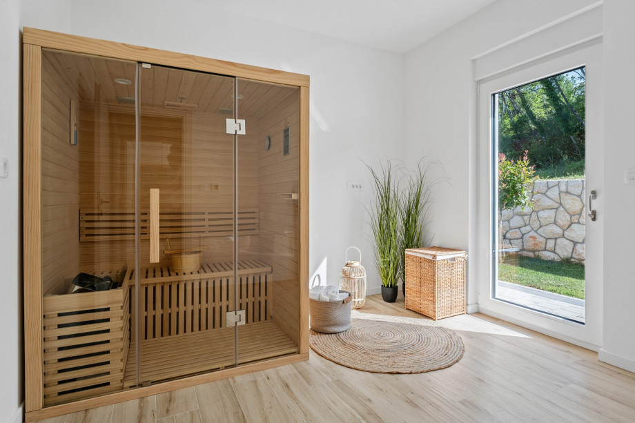 A relaxing Sauna room with a door toward the outdoors and the pool area