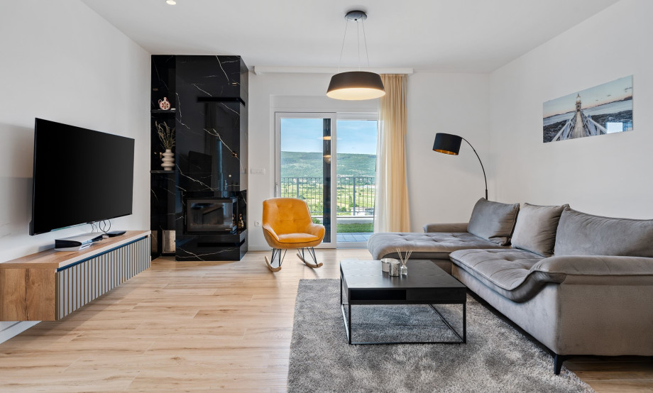 Das elegant eingerichtete Wohnzimmer verfügt über bequeme Sofas, einen Fernseher und eine Klimaanlage