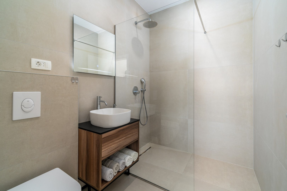 An en-suite bathroom with a shower, a sink, and a toilet