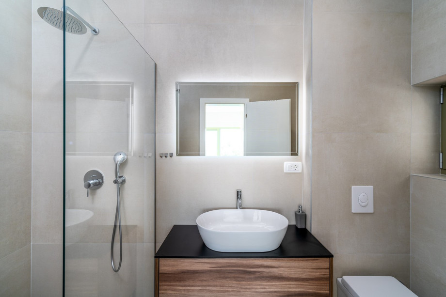 An en-suite bathroom with a shower, a sink, and a toilet