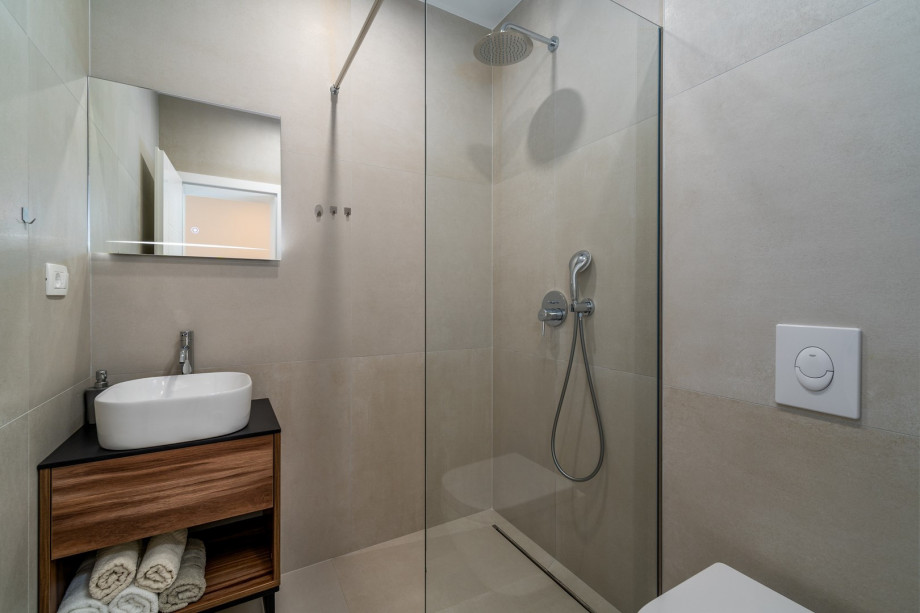 An en-suite bathroom with a shower, a sink, and a toilet