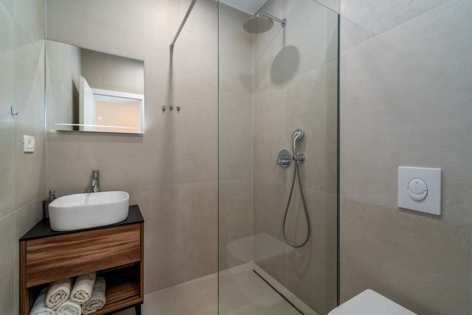 An en-suite bathroom with a shower, a sink, and a toilet