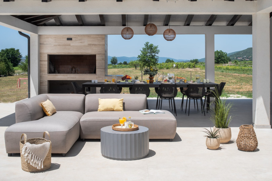 Relax in the outdoor sofa area with a refreshing drink, perfect for unwinding in the afternoon sun