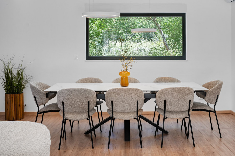 A large dining table that comfortably seats 8, ideal for family meals or enjoying the fresh local produce