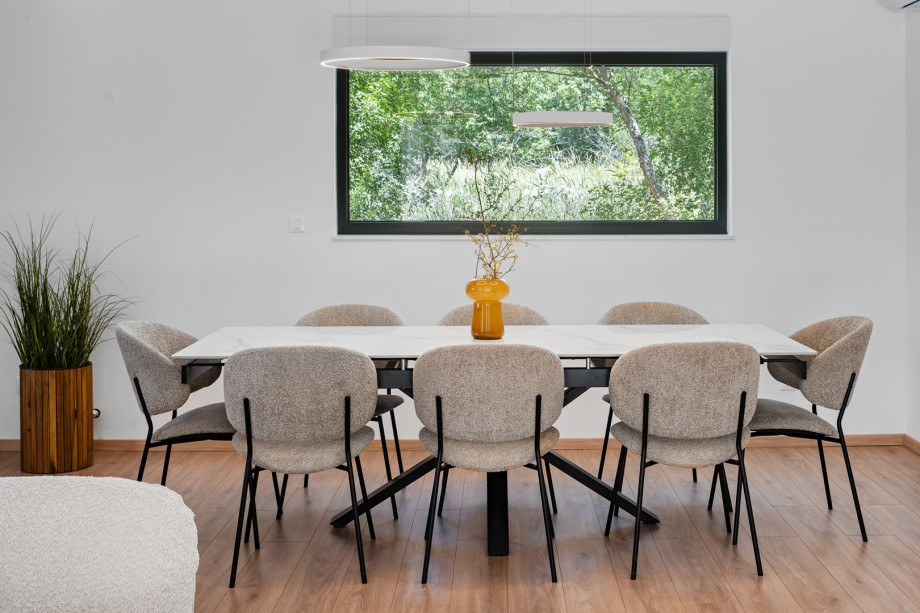 A large dining table that comfortably seats 8, ideal for family meals or enjoying the fresh local produce