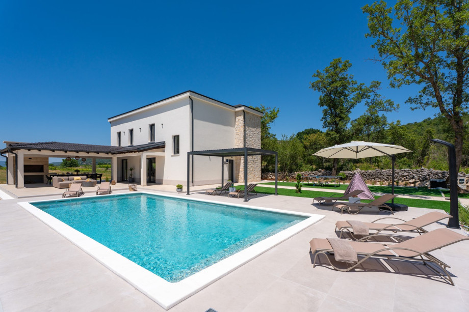 A covered dining area beckons guests to enjoy al fresco meals in style