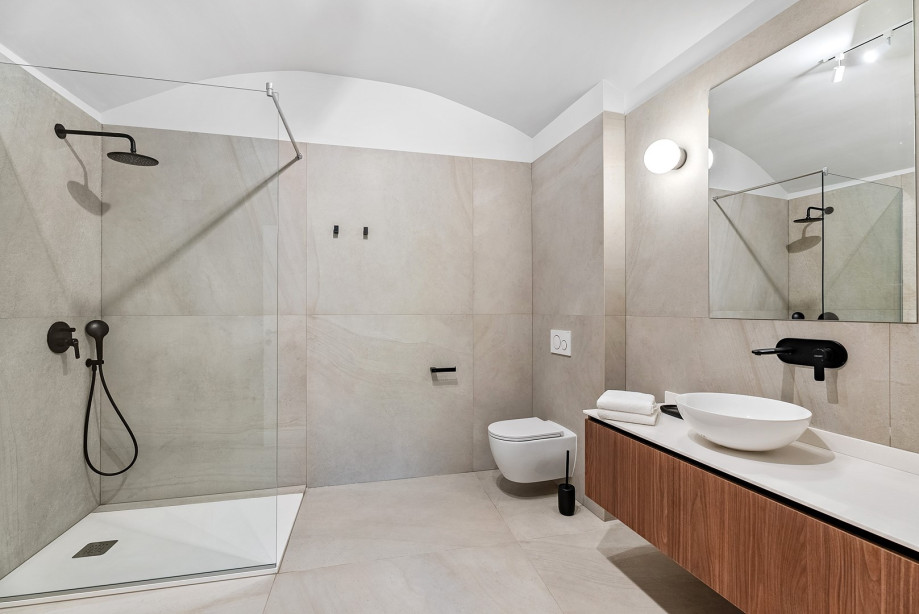 An en-suite bathroom with a shower, a sink, and a toilet