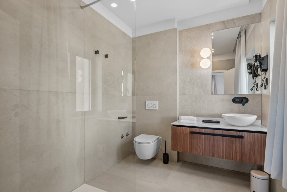 An en-suite bathroom with a shower, a sink, and a toilet