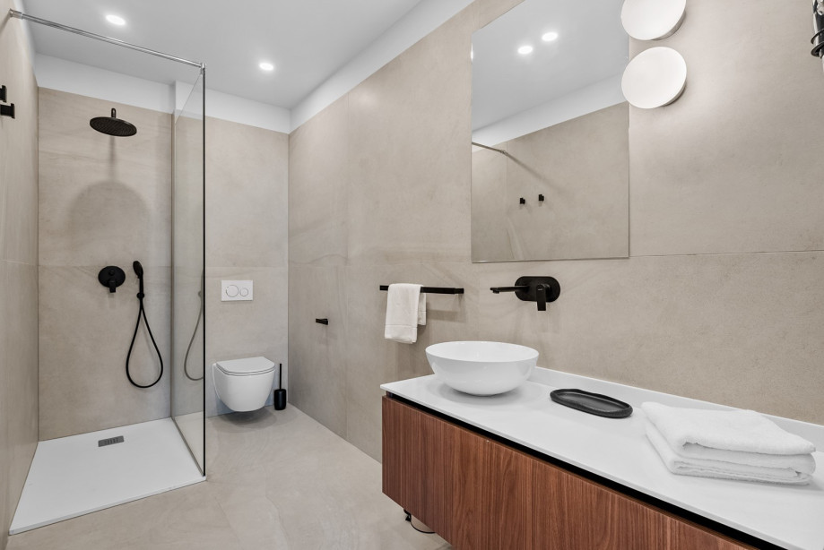 An en-suite bathroom with a shower, a sink, and a toilet