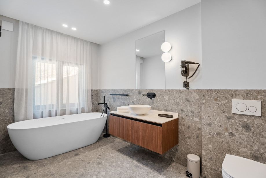 An en-suite bathroom with a bathtub, a sink, and a toilet