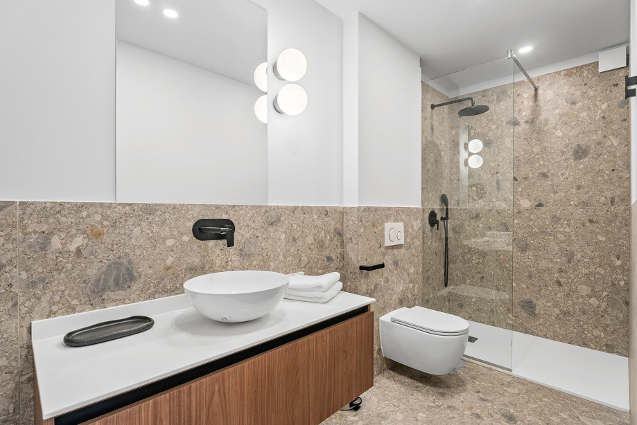 An en-suite bathroom with a shower, a sink, and a toilet