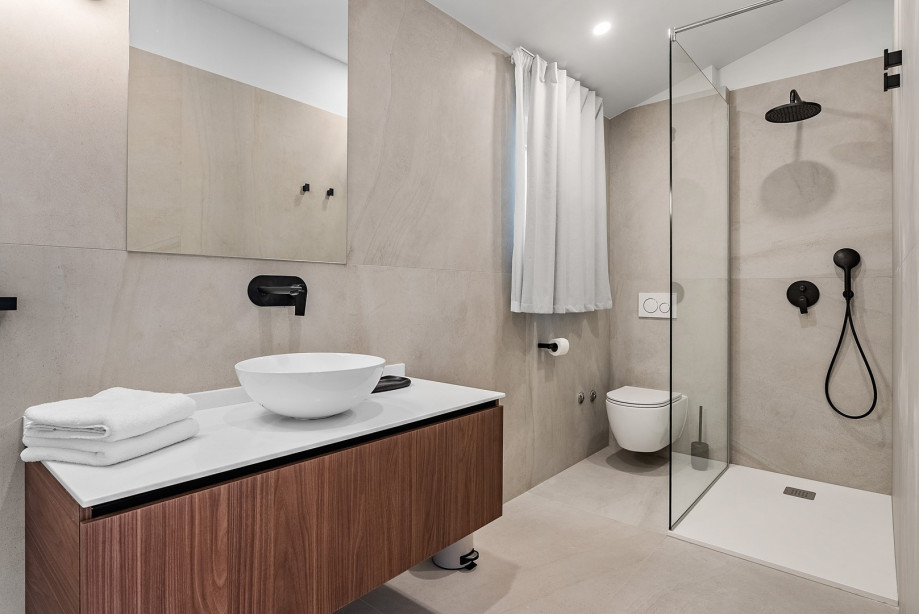 An en-suite bathroom with a shower, a sink, and a toilet