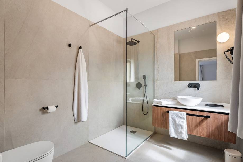 An en-suite bathroom with a shower, a sink, and a toilet