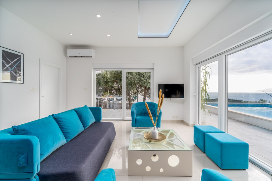 A spacious and modern living room with amazing pool and sea views