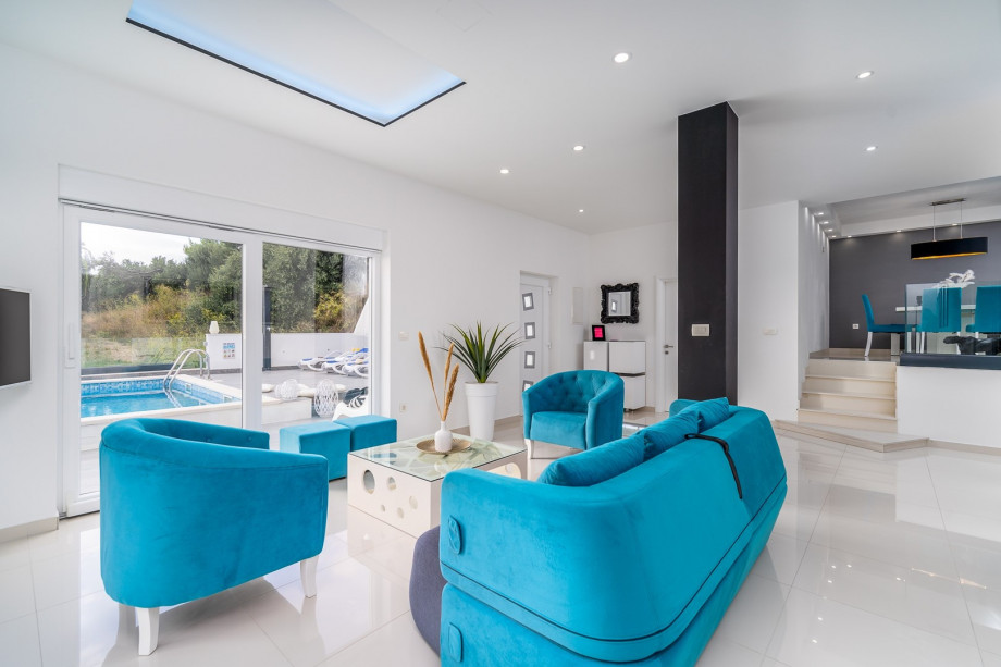 The living room is air conditioned and offers comfy sofas, SAT-TV and PS3