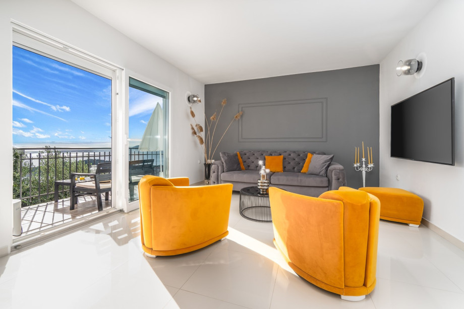 The living room is airconditioned and equipped with SAT-TV, offers an amazing pool and sea views