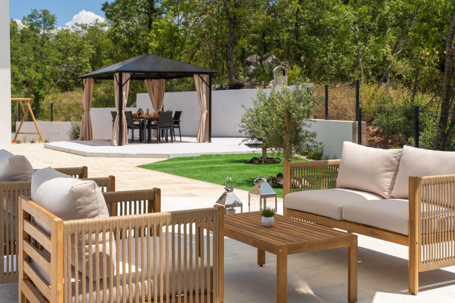 Relax in the outdoor sofa area with a refreshing drink, perfect for unwinding in the afternoon sun.