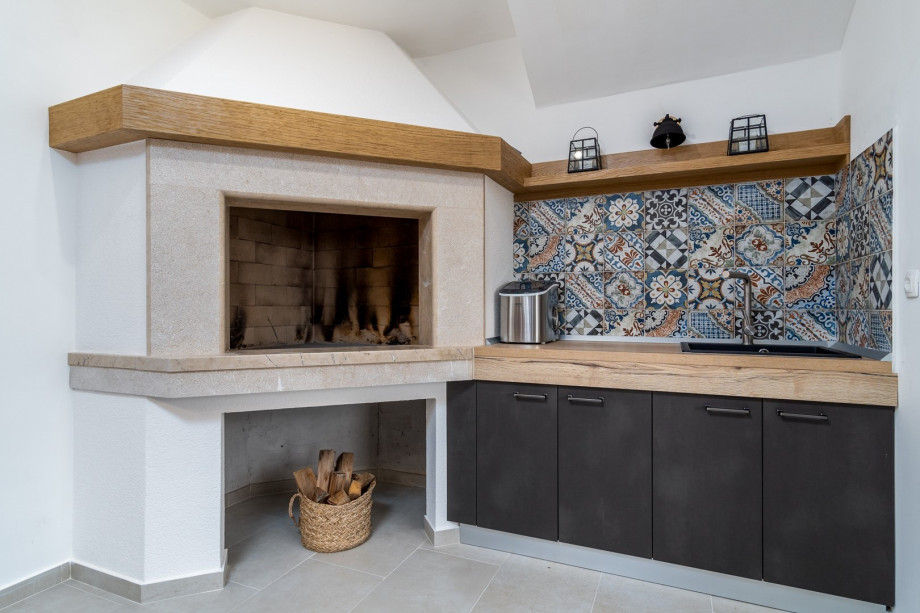 The ground floor also offers an indoor fireplace with an additional kitchen countertop