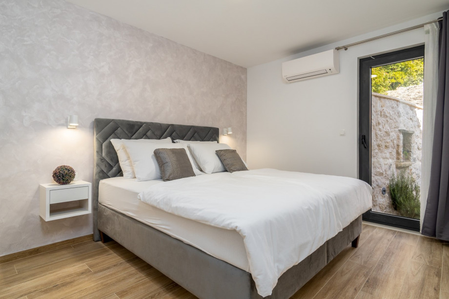 Bedroom No1 (ground floor) with king-size bed 180x200cm, en-suite bathroom and exit toward the outdoor dining area