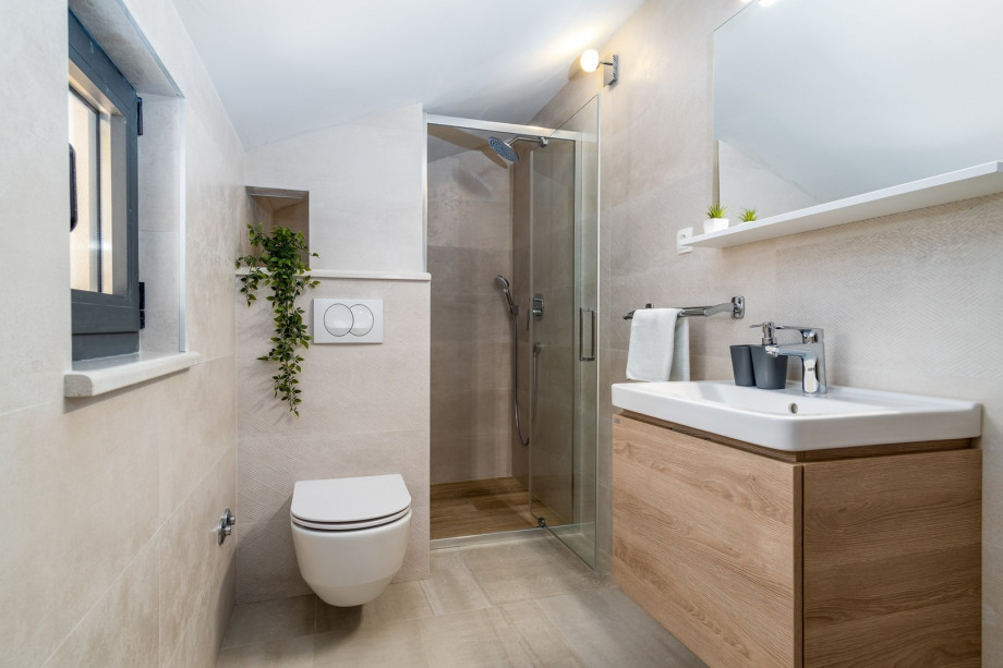 An en-suite bathroom with a shower, a sink, and a toilet