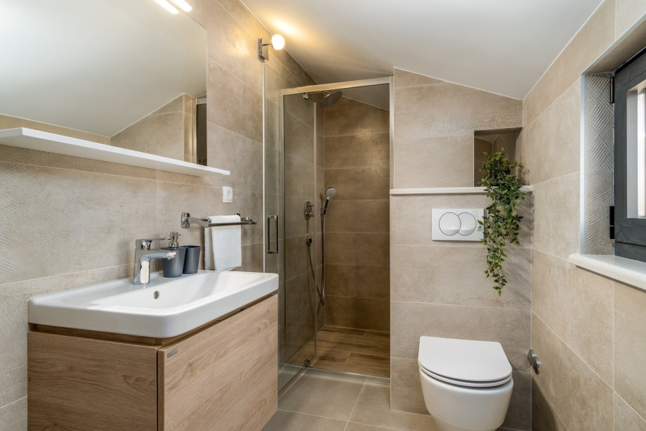 An en-suite bathroom with a shower, a sink, and a toilet