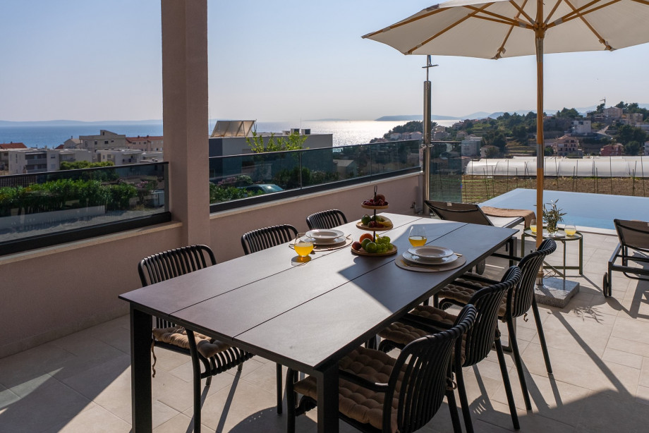 Covered dining terrace with seating for 8 and wood/charcoal BBQ