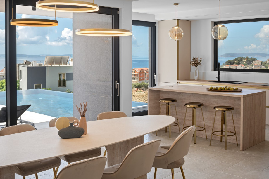Open-plan living/dining area with large glass doors to pool terrace