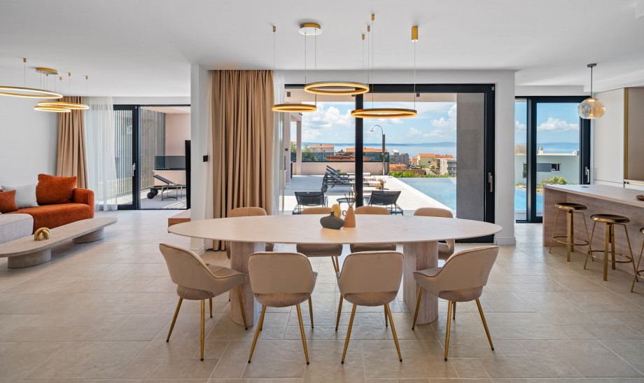 Large glass walls connect the villa's interior with the exterior, boasting a modern swimming pool area