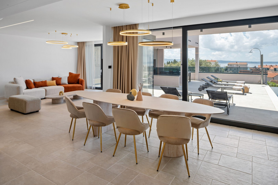 Open-plan living/dining area with large glass doors to pool terrace