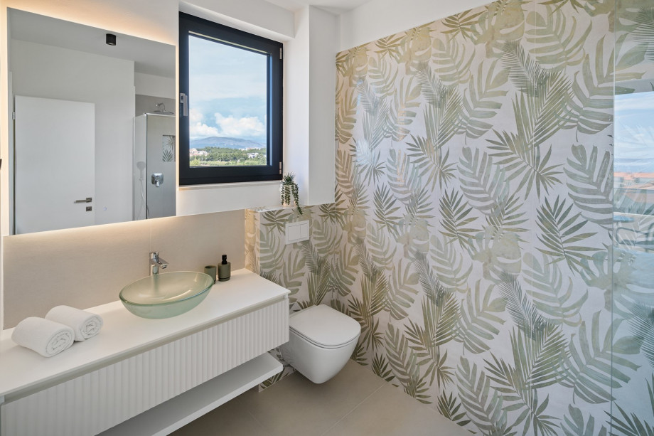 An en-suite bathroom with a shower, a sink, and a toilet