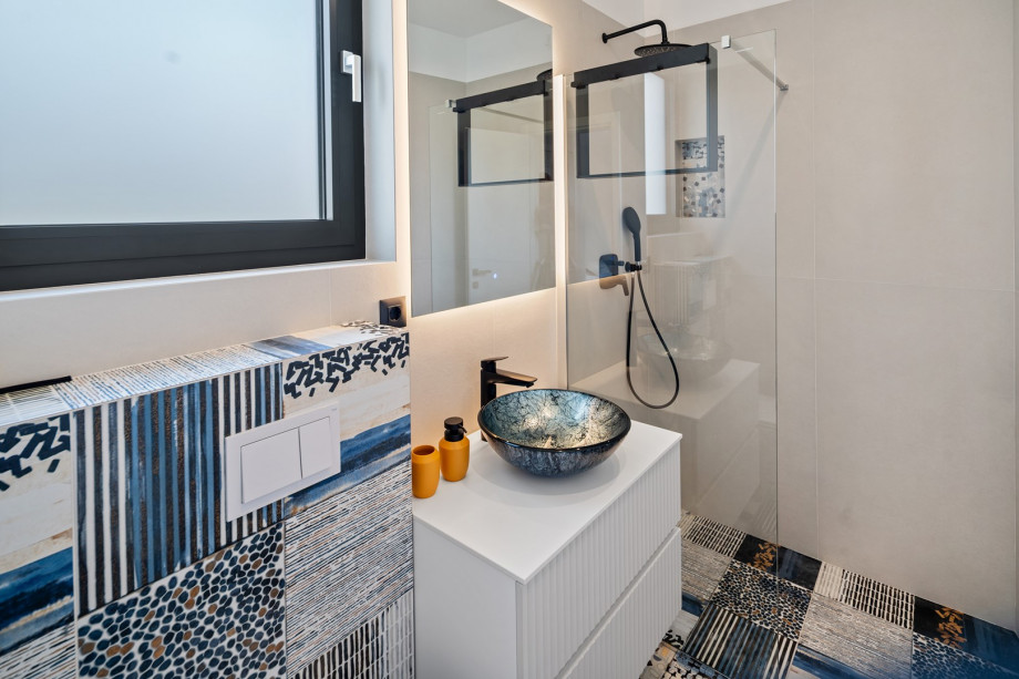 An en-suite bathroom with a shower, a sink, and a toilet