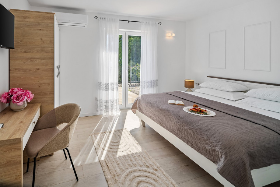 Bedroom No.3 with a AC / TV and a king-sized bed, en-suite bathroom and a sea view