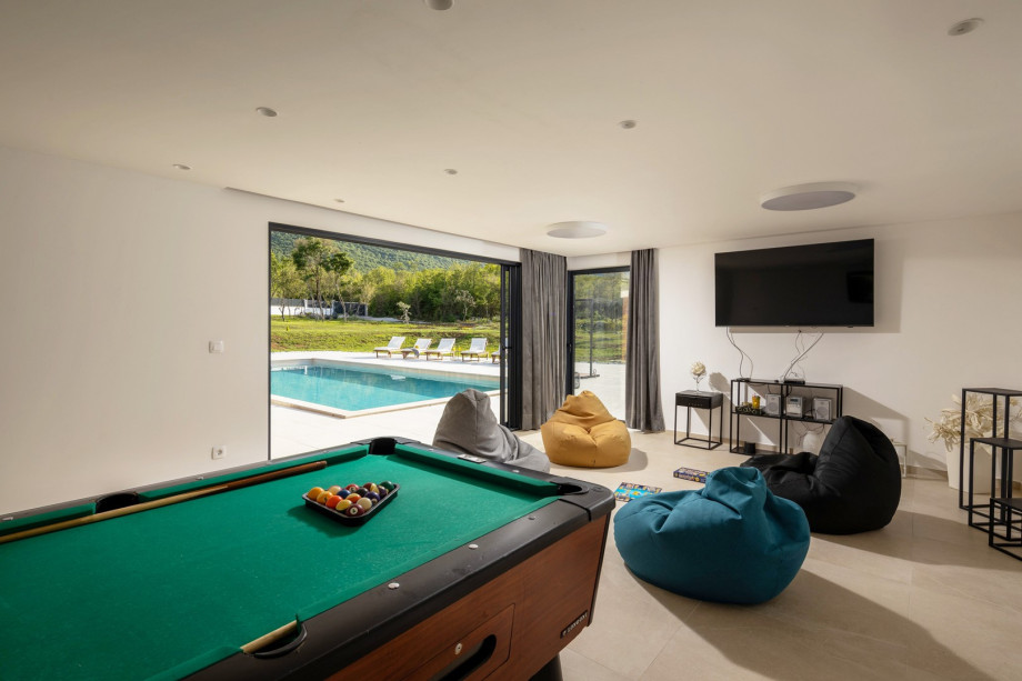 There is a Playroom with a Billiard (A Pool table), a flat-screen TV, lazy bags, JGB speakers, A/C, and a direct approach to the pool area