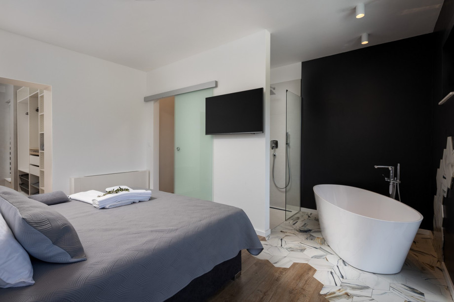 An en-suite bathroom with a shower and a self-standing bathtub