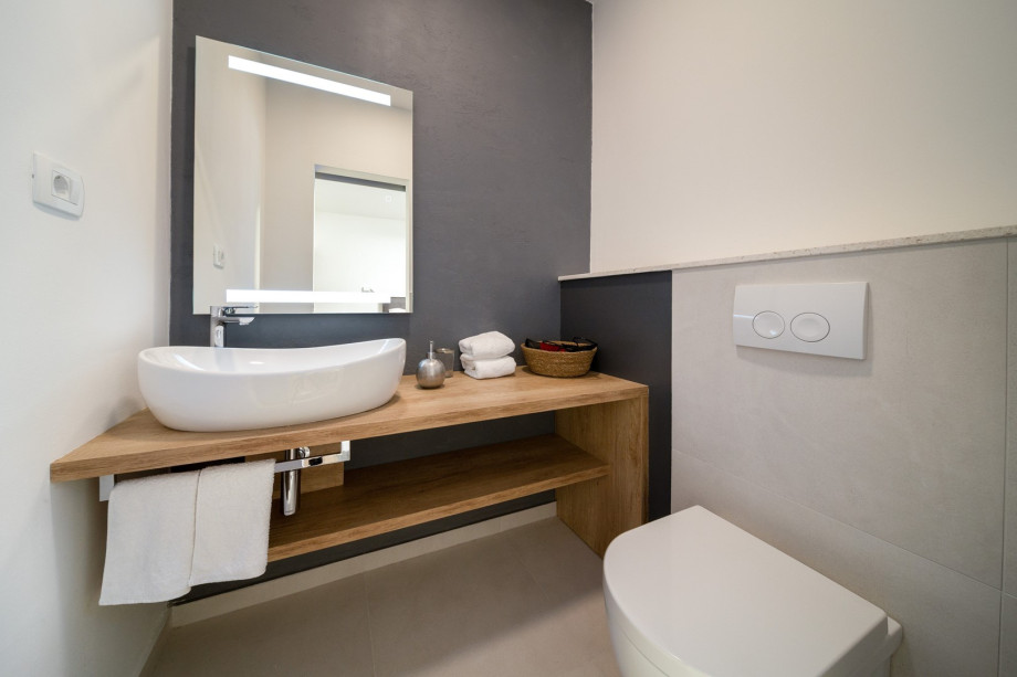 An en-suite bathroom with a shower, a self-standing bathtub, a sink, and a toilet