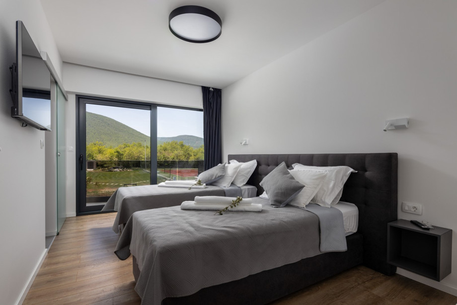 Bedroom No3 with two single beds 90cmx 200cm, A/C, TV, en-suite bathroom with a shower, a balcony