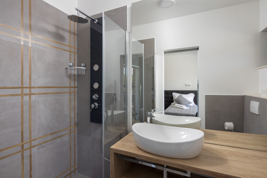 An en-suite bathroom with a shower, a sink, and a toilet