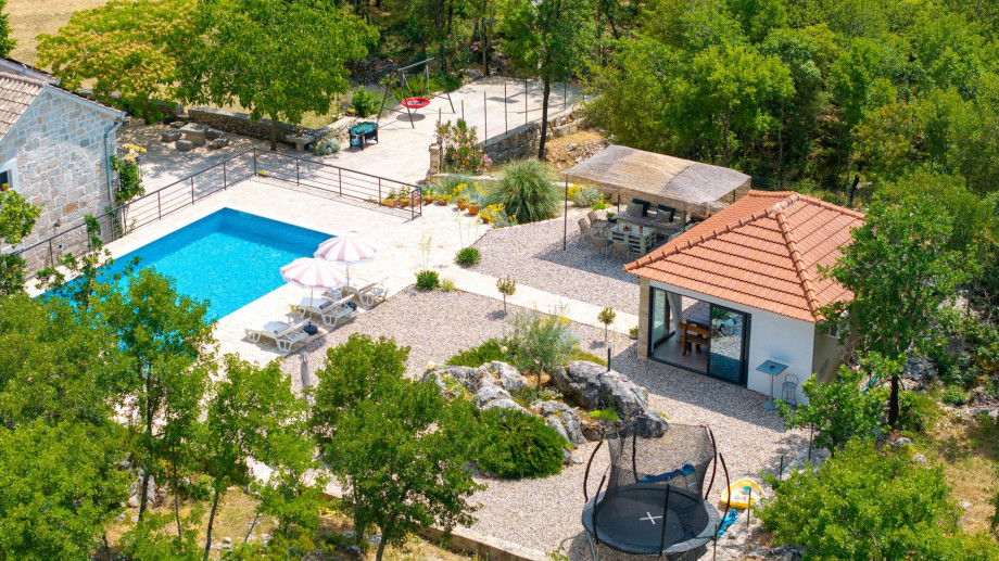 The outdoor area also offers a lounge corner and a fully equipped summer kitchen with traditional barbecue area, dining tables, a TV and a separate toilet.