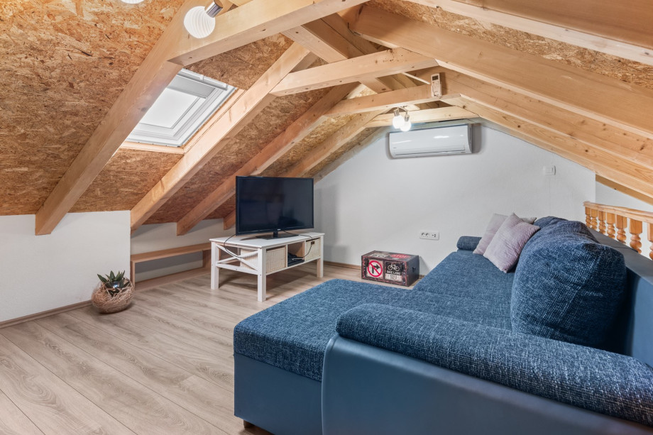 Few more steps to get to the gallery with a sofa, a flat screen TV and a Play Station 4.