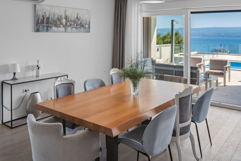 A dining area with a direct exit to the pool/lounge area with an amazing sea views