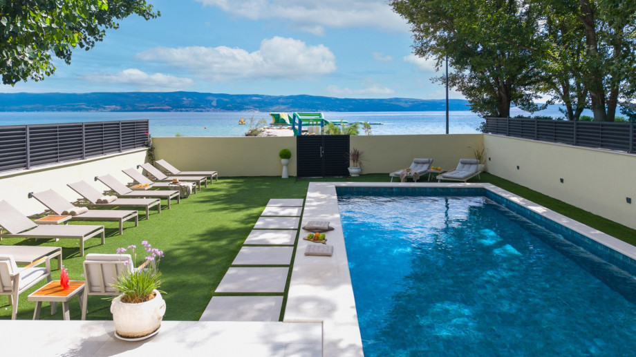The sun deck area with 14 deck chairs, an outdoor shower, summer kitchen