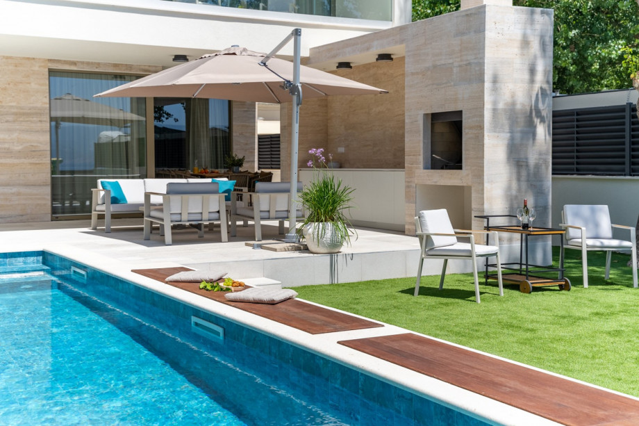 A summer kitchen with a traditional barbecue, lounge corner