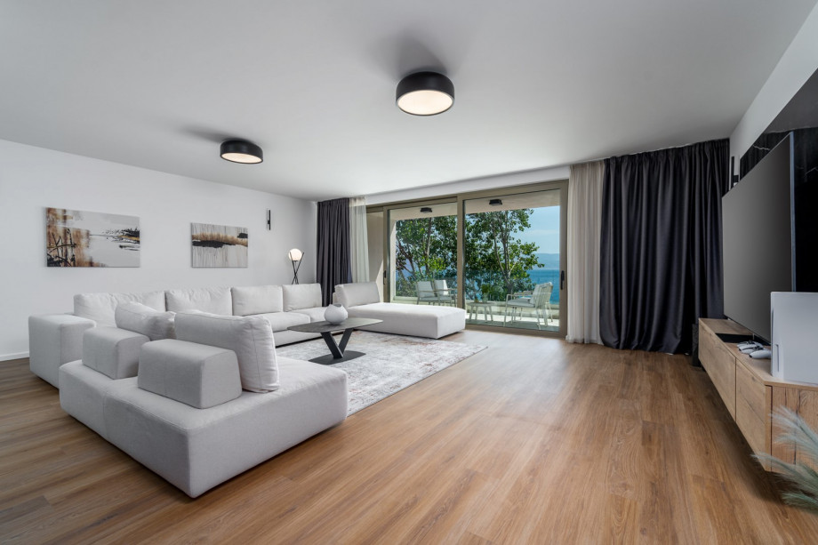 Spacious living room 63 sqm South oriented with comfortable and stylish sofas, a huge flat-screen TV, and Play Station 5