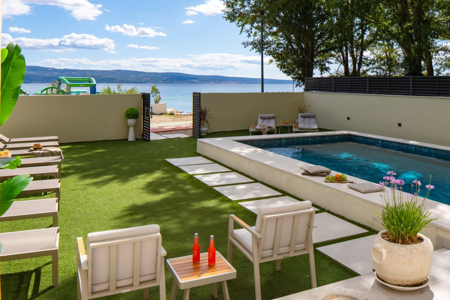 The sun deck area with 14 deck chairs, an outdoor shower, summer kitchen