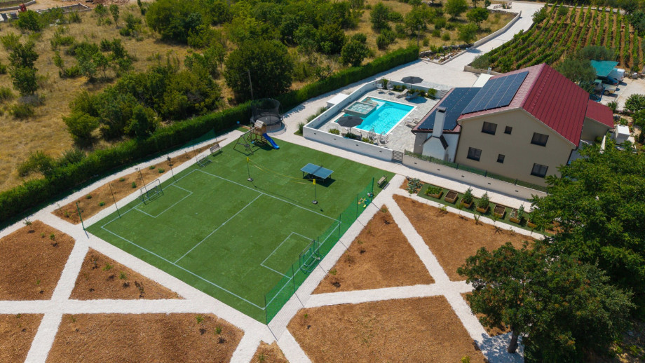 Play area featuring a 21m x 18m football pitch with soft artificial grass and an easy-to-set-up badminton net