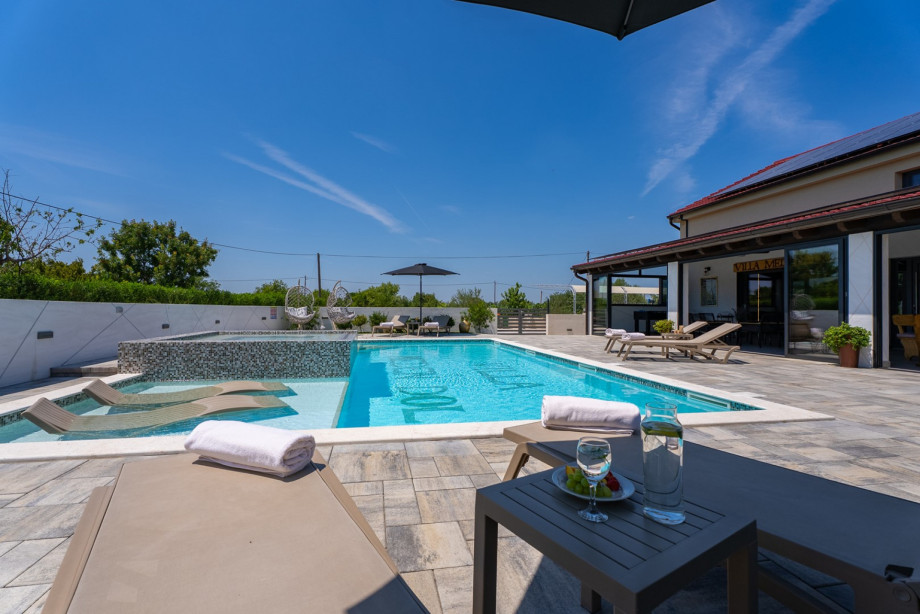 Large sun-bathed patio next to the pool, perfect for soaking up the sun