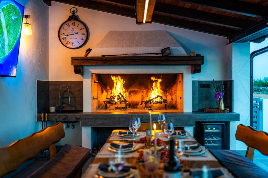 Outdoor dining area with extra refrigerator, a sink, and a cozy lounge corner that is easily accessible from the kitchen