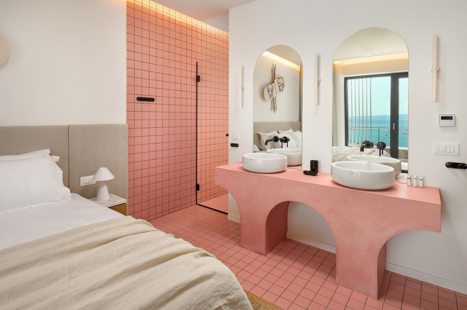 An en-suite bathroom with a shower, a double sink, and a toilet