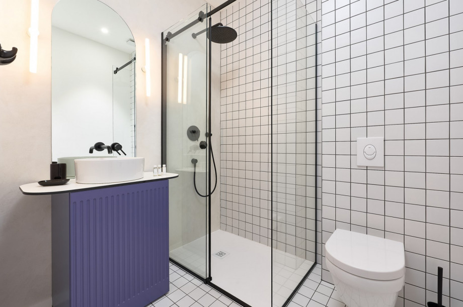 An en-suite bathroom with a shower, a sink, and a toilet